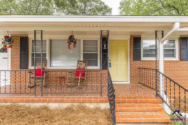 123 Robinhood Dr, Warner Robins, GA 31088 - view of exterior entry with brick siding and a porch