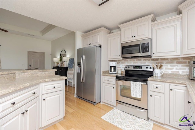 133 Gage Dr, Perry, GA 31069 - kitchen featuring stainless steel appliances, decorative backsplash, light wood-style floors, and white cabinets