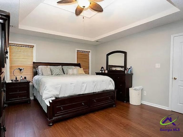 108 Christine, Perry, GA 31069 - bedroom featuring a tray ceiling, dark wood-style floors, baseboards, and a ceiling fan