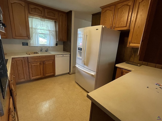 122 Cheryl Blvd, Warner Robins, GA 31088 - kitchen featuring white appliances, light floors, brown cabinets, light countertops, and a sink