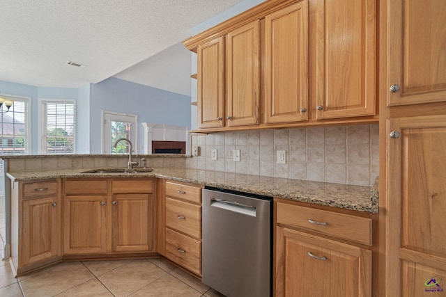 107 Rachael Ln, Warner Robins, GA 31088 - kitchen featuring stainless steel dishwasher, light tile patterned floors, light stone counters, a peninsula, and decorative backsplash