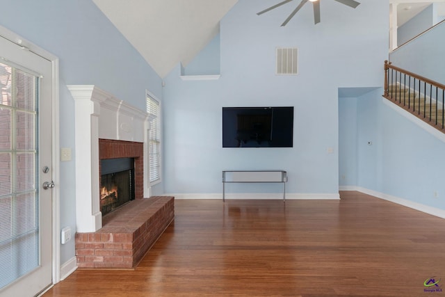 107 Rachael Ln, Warner Robins, GA 31088 - unfurnished living room with ceiling fan, a fireplace, wood finished floors, high vaulted ceiling, and stairway