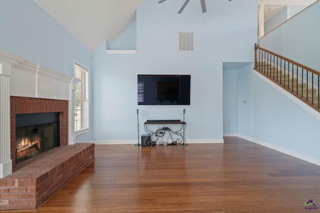 107 Rachael Ln, Warner Robins, GA 31088 - living room with high vaulted ceiling, a fireplace, wood finished floors, stairs, and a ceiling fan
