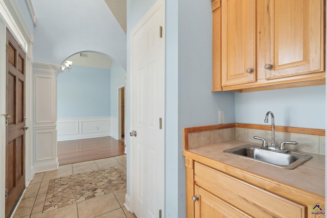 107 Rachael Ln, Warner Robins, GA 31088 - kitchen featuring light tile patterned flooring, light countertops, arched walkways, and light brown cabinets