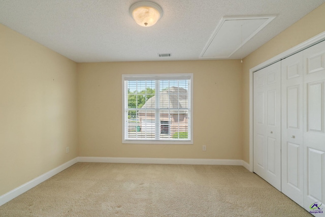 107 Rachael Ln, Warner Robins, GA 31088 - unfurnished bedroom featuring attic access, carpet, a closet, and a textured ceiling