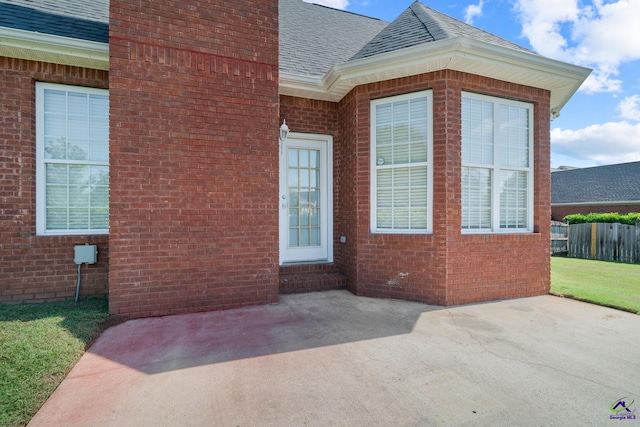 107 Rachael Ln, Warner Robins, GA 31088 - view of exterior entry with a shingled roof, a patio, and brick siding