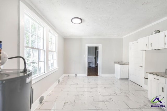 138 Comer Ter, Macon, GA 31204 - kitchen featuring light marble finish floors, a textured ceiling, electric water heater, stone counters, and white cabinetry
