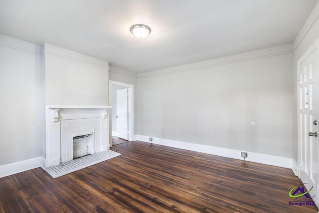 138 Comer Ter, Macon, GA 31204 - unfurnished living room featuring dark wood-style flooring, baseboards, and a tiled fireplace