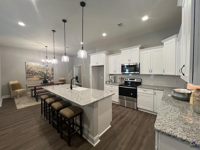 508 Nandina Ct, Warner Robins, GA 31088 - kitchen with stainless steel appliances, a sink, dark wood-style floors, tasteful backsplash, and white cabinets