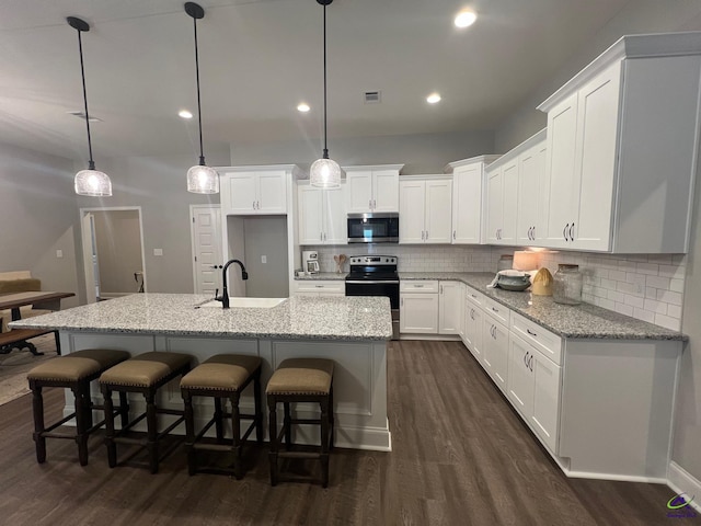 508 Nandina Ct, Warner Robins, GA 31088 - kitchen with stainless steel microwave, electric range, a sink, dark wood-style floors, and decorative backsplash