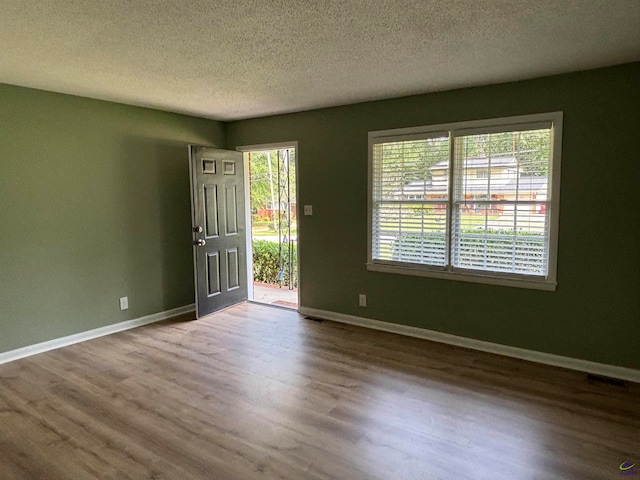 867 S Forest Lake Dr, Macon, GA 31201 - unfurnished room featuring wood finished floors, a textured ceiling, healthy amount of natural light, and baseboards