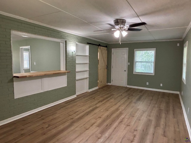 867 S Forest Lake Dr, Macon, GA 31201 - unfurnished living room featuring a barn door, wood finished floors, baseboards, crown molding, and a ceiling fan