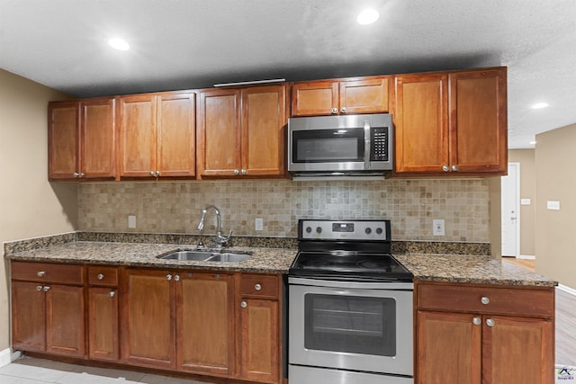 2105 Mutual Ave, Macon, GA 31204 - kitchen featuring appliances with stainless steel finishes, a sink, baseboards, backsplash, and dark stone counters