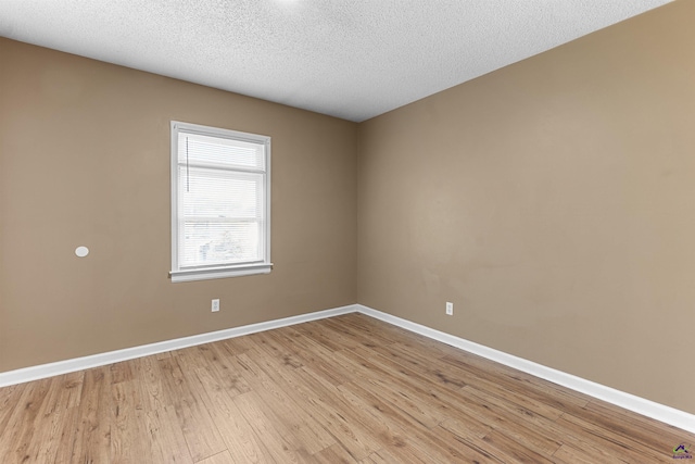 2105 Mutual Ave, Macon, GA 31204 - spare room with baseboards, light wood-type flooring, and a textured ceiling