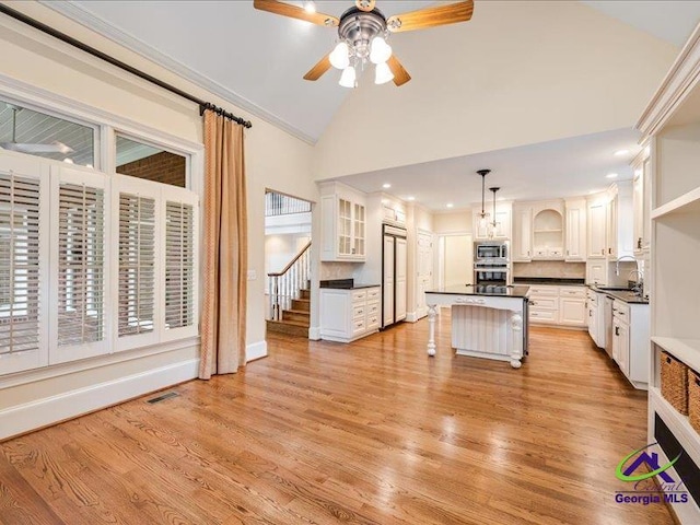 113 Troon Way, Macon, GA 31210 - kitchen featuring dark countertops, a sink, a ceiling fan, light wood finished floors, and white cabinetry