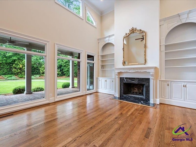 113 Troon Way, Macon, GA 31210 - unfurnished living room with built in shelves, ornamental molding, a high end fireplace, wood finished floors, and a high ceiling