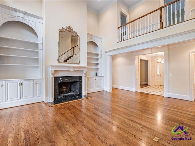 113 Troon Way, Macon, GA 31210 - unfurnished living room with built in shelves, crown molding, baseboards, wood finished floors, and a high ceiling