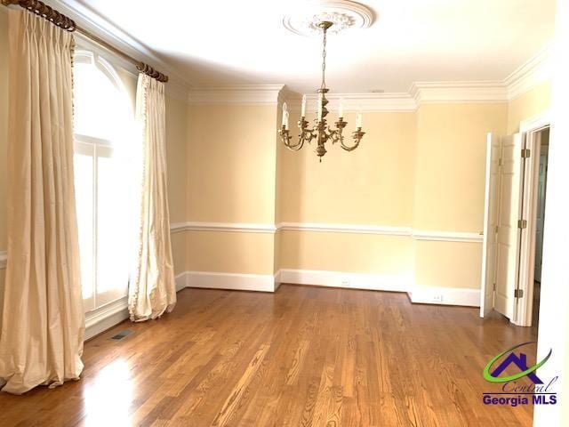 113 Troon Way, Macon, GA 31210 - unfurnished dining area featuring a chandelier, crown molding, wood finished floors, and baseboards