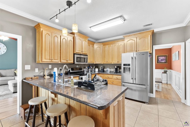 2725 Moseley Rd, Byron, GA 31008 - kitchen with appliances with stainless steel finishes, light brown cabinets, a sink, a breakfast bar, and light tile patterned floors