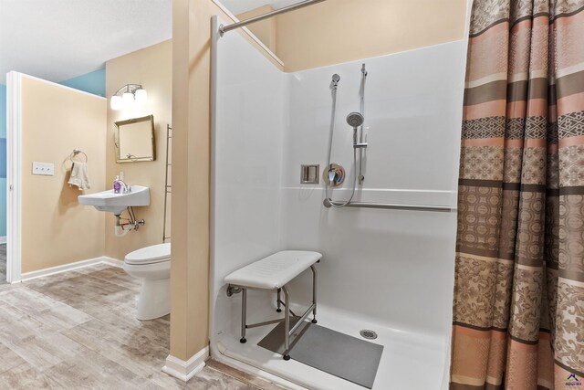 2725 Moseley Rd, Byron, GA 31008 - bathroom featuring a shower stall, wood finished floors, toilet, a sink, and baseboards