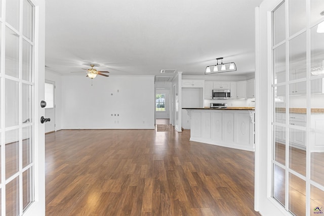 2725 Moseley Rd, Byron, GA 31008 - unfurnished living room featuring dark wood finished floors, ceiling fan, attic access, and baseboards
