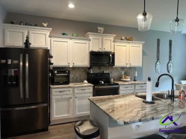 403 Hunts Landing Dr, Kathleen, GA 31047 - kitchen with black appliances, white cabinetry, tasteful backsplash, and light stone countertops