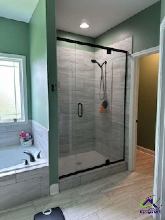 403 Hunts Landing Dr, Kathleen, GA 31047 - bathroom with a shower stall, a bath, and tile patterned floors