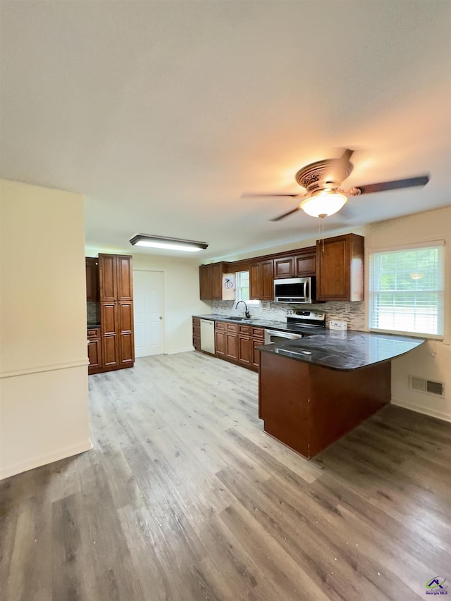 221 Fox Hound Dr, Byron, GA 31008 - kitchen with appliances with stainless steel finishes, a sink, a peninsula, and light wood-type flooring