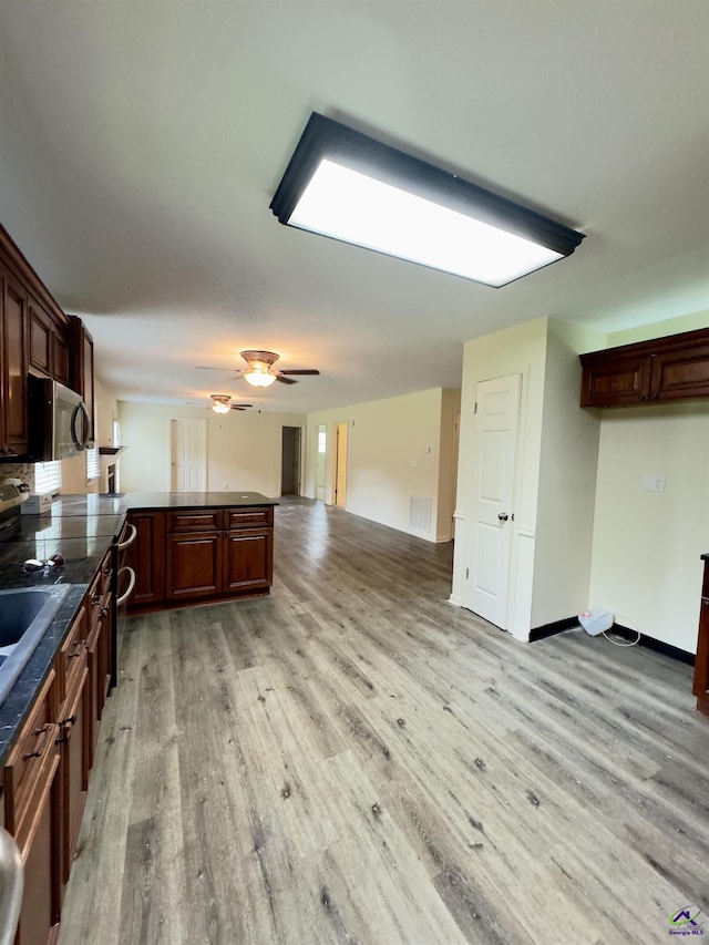 221 Fox Hound Dr, Byron, GA 31008 - kitchen with light wood-style flooring, a peninsula, stainless steel microwave, dark countertops, and open floor plan