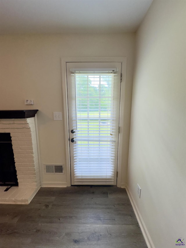221 Fox Hound Dr, Byron, GA 31008 - doorway to outside with wood finished floors, a brick fireplace, and baseboards