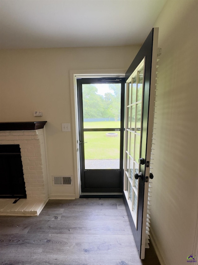 221 Fox Hound Dr, Byron, GA 31008 - doorway with wood finished floors, baseboards, a brick fireplace, and french doors