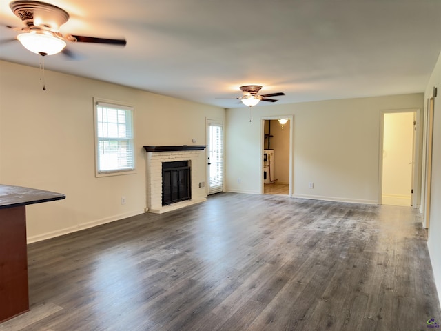 221 Fox Hound Dr, Byron, GA 31008 - unfurnished living room featuring ceiling fan, a fireplace, dark wood-style floors, and baseboards