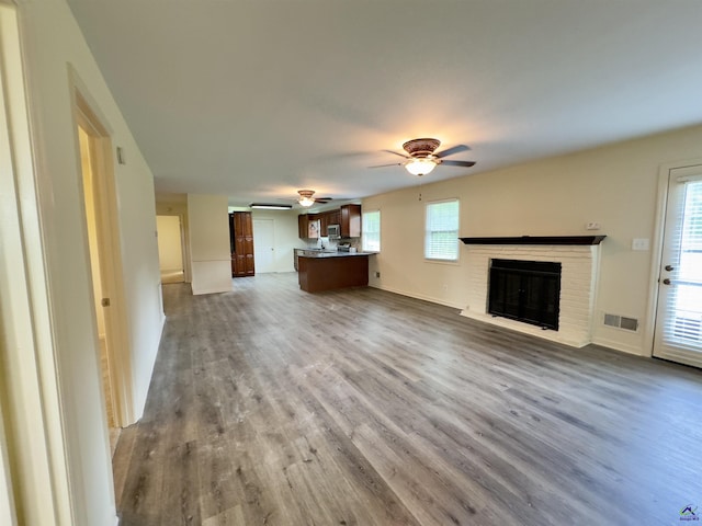 221 Fox Hound Dr, Byron, GA 31008 - unfurnished living room featuring a ceiling fan, wood finished floors, a brick fireplace, and baseboards