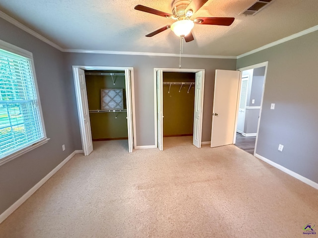 424 Wexford Cir, Bonaire, GA 31005 - unfurnished bedroom with multiple closets, carpet floors, ornamental molding, baseboards, and a ceiling fan