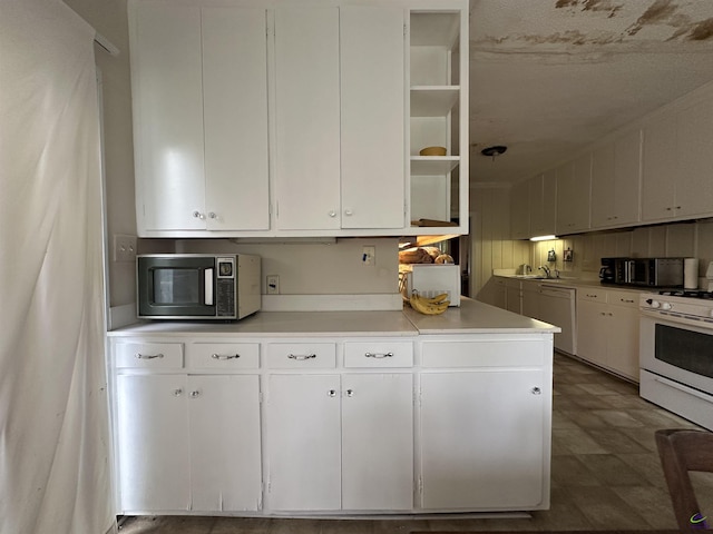 621 Forest Hill Rd, Macon, GA 31220 - kitchen featuring stainless steel microwave, white gas range oven, dishwashing machine, white cabinetry, and light countertops