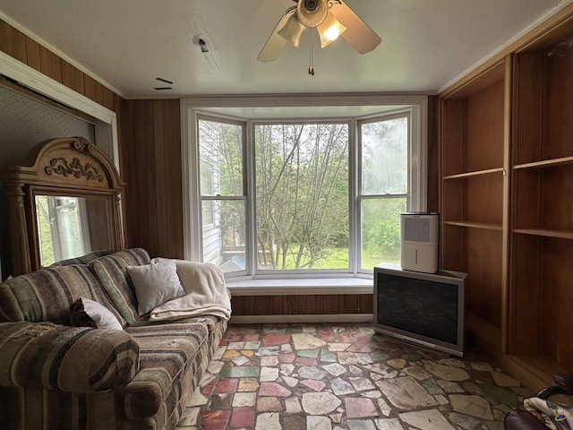 621 Forest Hill Rd, Macon, GA 31220 - living room with stone finish floors, wood walls, ceiling fan, and crown molding