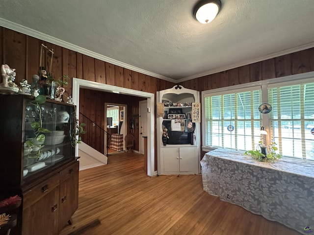 621 Forest Hill Rd, Macon, GA 31220 - dining area with wooden walls, light wood-type flooring, ornamental molding, stairs, and a textured ceiling
