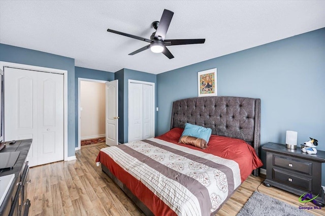 117 Richfield Cir, Kathleen, GA 31047 - bedroom featuring two closets, light wood finished floors, baseboards, ceiling fan, and a textured ceiling