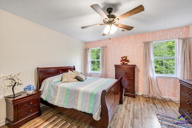 117 Richfield Cir, Kathleen, GA 31047 - bedroom with light wood-style floors, a textured ceiling, wallpapered walls, baseboards, and a ceiling fan