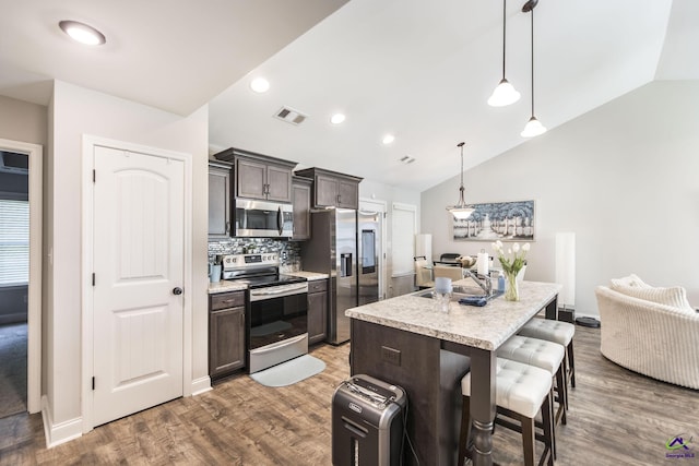 224 Allentown Ln, Macon, GA 31216 - kitchen featuring stainless steel appliances, lofted ceiling, a sink, a kitchen bar, and dark brown cabinets