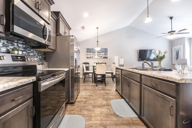 224 Allentown Ln, Macon, GA 31216 - kitchen featuring appliances with stainless steel finishes, dark brown cabinetry, ceiling fan, vaulted ceiling, and tasteful backsplash