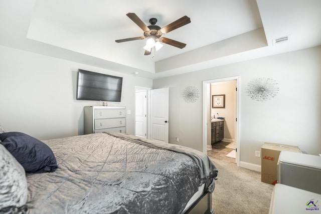 224 Allentown Ln, Macon, GA 31216 - bedroom featuring a tray ceiling, light carpet, baseboards, ensuite bathroom, and ceiling fan
