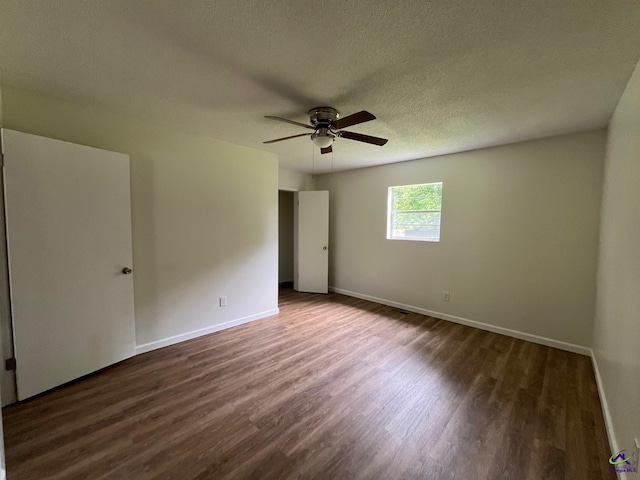 571 Duncan Ave, Unadilla, GA 31091 - unfurnished bedroom featuring dark wood-style flooring, baseboards, a ceiling fan, and a textured ceiling