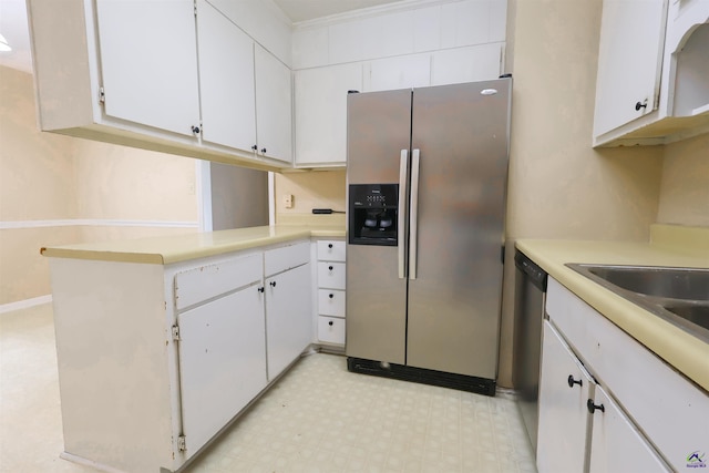 901 Ross St, Perry, GA 31069 - kitchen with stainless steel appliances, light countertops, white cabinets, and light floors