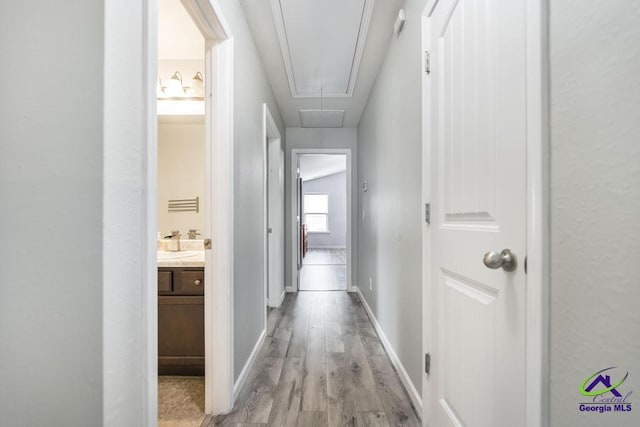 318 Flowing Meadows Dr, Bonaire, GA 31047 - hallway featuring attic access, light wood-type flooring, a sink, and baseboards