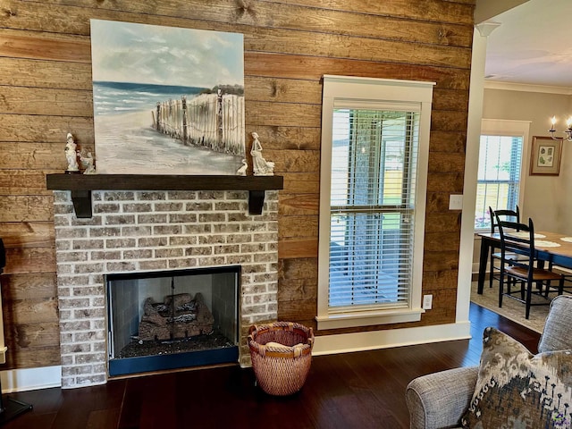 204 Bobtail Run, Kathleen, GA 31047 - living room featuring ornamental molding, wood finished floors, wooden walls, a brick fireplace, and baseboards