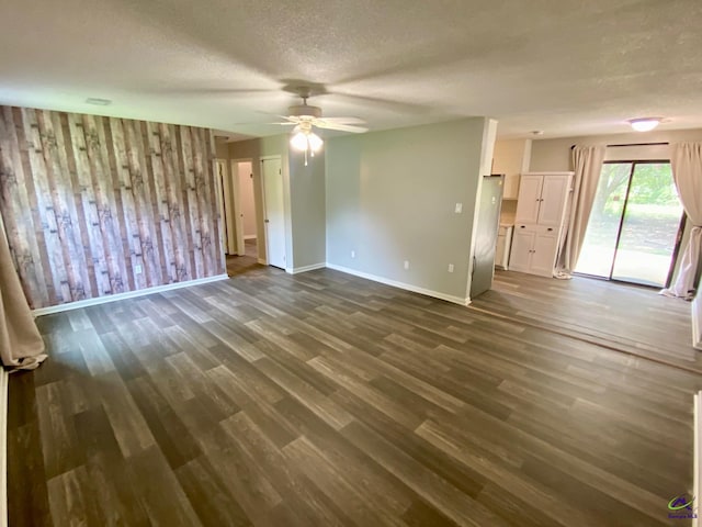 403 Fieldstone Rd, Warner Robins, GA 31093 - unfurnished living room with a ceiling fan, dark wood-style floors, baseboards, a textured ceiling, and wood walls