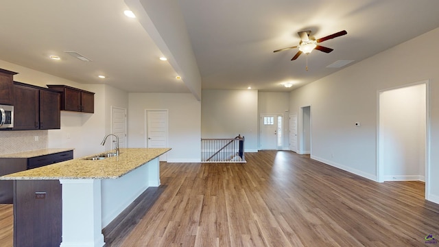 444 Southern Oaks Dr, Macon, GA 31216 - kitchen with a sink, stainless steel microwave, ceiling fan, light wood-style floors, and a kitchen island with sink