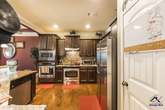 101 Regency Ct, Warner Robins, GA 31088 - kitchen with stainless steel appliances, dark brown cabinets, tasteful backsplash, dark wood-style floors, and light stone counters