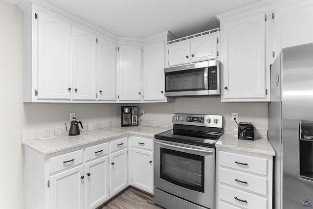 111 Venus Way, Bonaire, GA 31005 - kitchen with stainless steel appliances, white cabinets, and wood finished floors